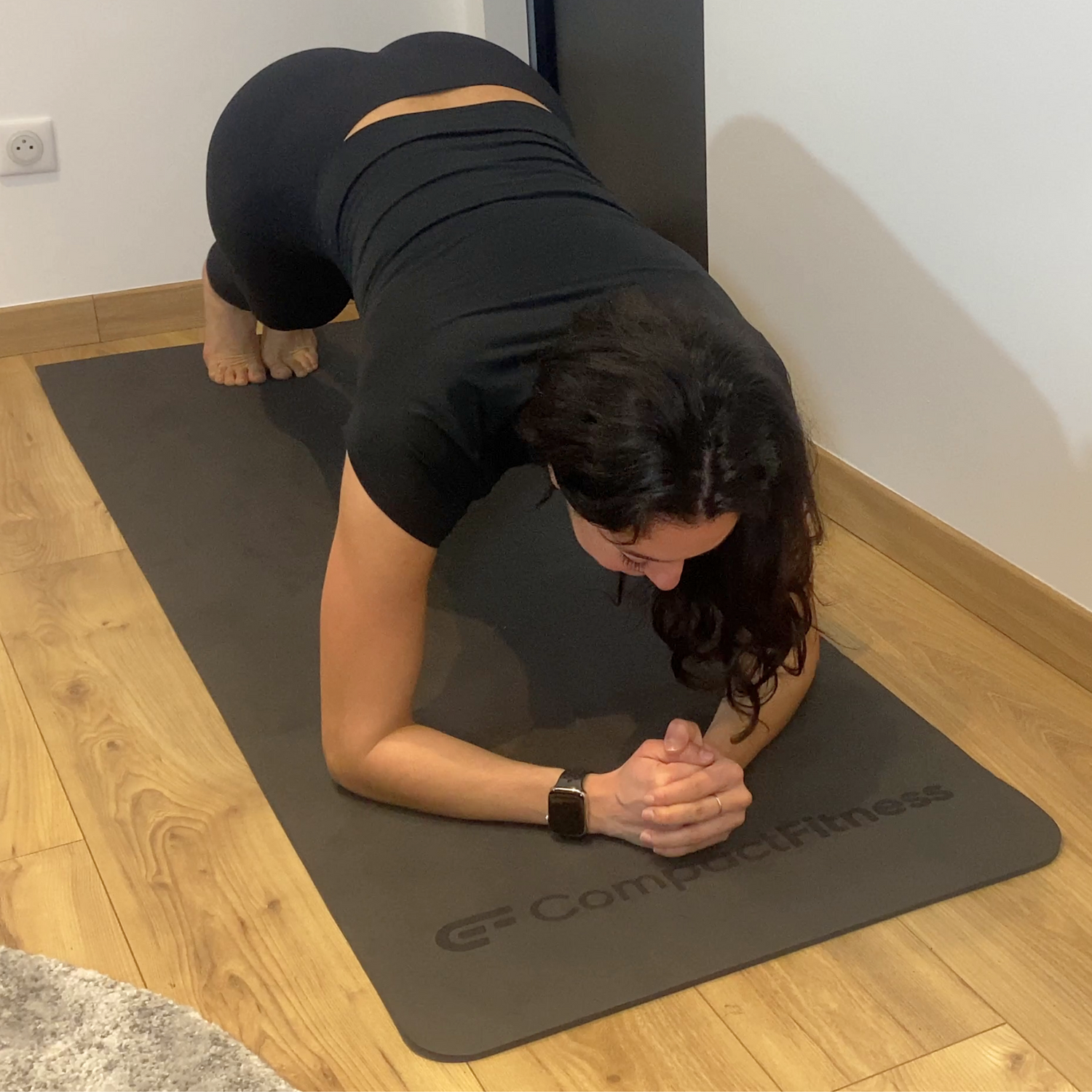 Exercice de planche en gainage isométrique sur un tapis de sol de la marque Compact Fitness